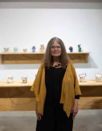 Headshot of Deb King in front of ceramic vases.